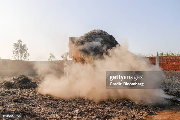 Residue ash containing semi-burnt plastic bags from a steam boiler of a paper mill arrives at a scrap yard in Muzaffarnagar District, Uttar Pradesh,...