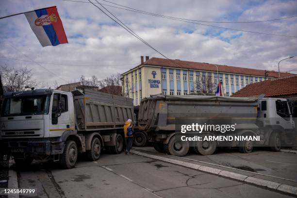 Pedestrian walks past a new road barricade set up in the divided town of Mitrovica on December 28, 2022. - On December 10, 2022 Serbs in northern...