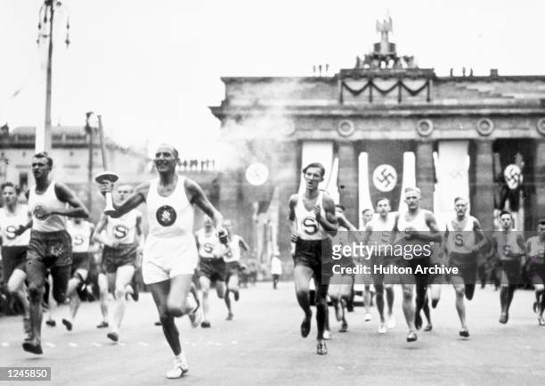 The torch bearer runs through the streets en route to the Olympic Stadium in Berlin, Germany. Mandatory Credit: Allsport Hulton/Archive