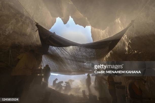 Members of the Israel Antiquities Authority team sift soil at an excavation site in the Murabaat cave in the Judean Desert area near the Dead Sea, on...