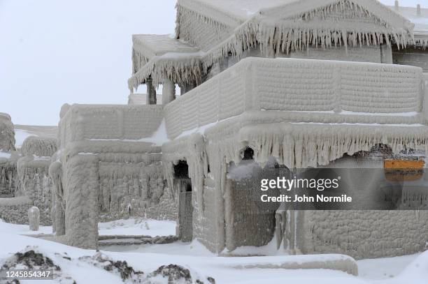 Homes are covered with ice after being battered with waves from Lake Erie along Hoover Beach on December 27, 2022 in Hamburg, New York. The historic...