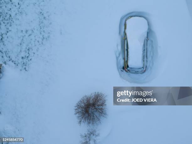 In this aerial photo, a car is still buried in the blizzards snow in Buffalo, New York, on December 28, 2022. - The monster storm that killed dozens...