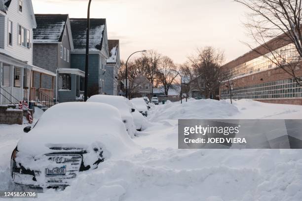 Buried cars line Lowell Place in Buffalo, New York on December 28, 2022. - The monster storm that killed dozens in the US over the Christmas weekend...