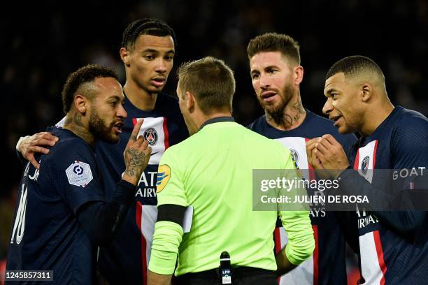 Paris Saint-Germain's Brazilian forward Neymar reacts after receiving a red card from French referee Clement Turpin next to Paris Saint-Germain's...