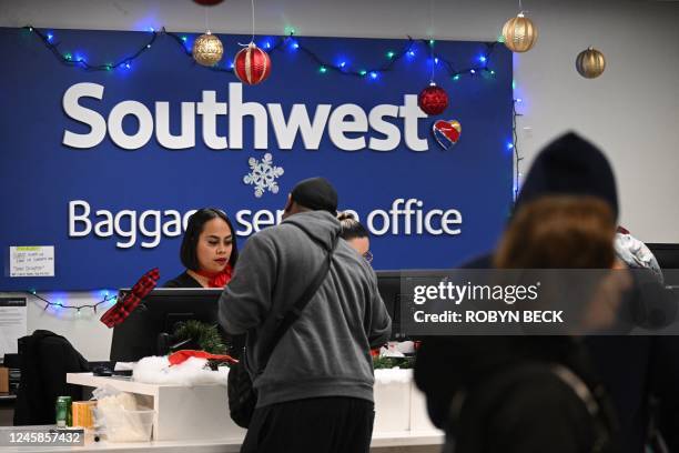 Ground crew members help passengers who cannot find their luggage at the Southwest Airlines baggage claim area, December 28, 2022 at Los Angeles...