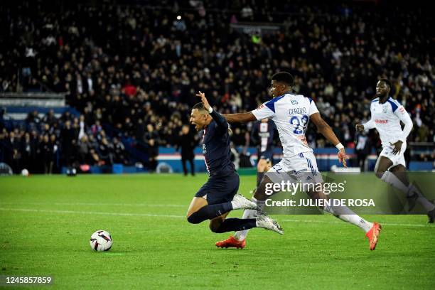 Strasbourg's French defender Gerzino Nyamsi makes a fault on Paris Saint-Germain's French forward Kylian Mbappe and gives a penalty during the French...