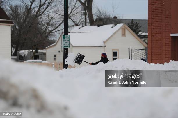 Man clears his sidewalk along South Park Avenue on December 28, 2022 in Buffalo, New York. The historic Winter Storm Elliott dumped up to four feet...