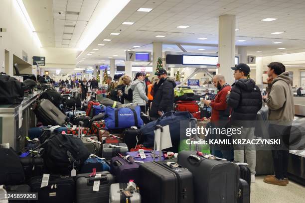 Stranded Southwest Airlines passengers looks for their luggage in the baggage claim area at Chicago Midway International Airport in Chicago,...