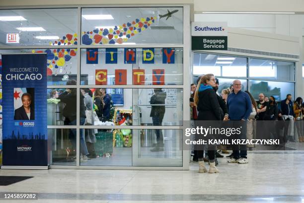 Travellers wait in line to speak with Southwest Airlines baggage service agents in the baggage claim area of Chicago Midway International Airport in...