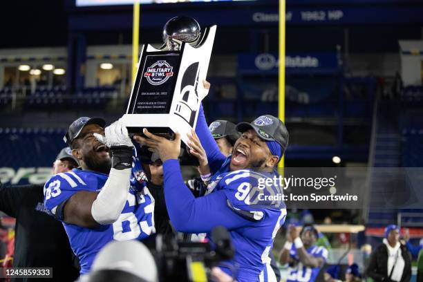 Duke Blue Devils defensive tackle DeWayne Carter and Duke Blue Devils offensive lineman Jacob Monk holds up the Military Bowl Championship trophy...