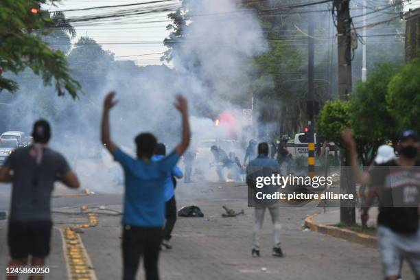 December 2022, Bolivia, Santa Cruz: Protesters throw gas grenades at police officers after the arrest of opposition leader Camacho. The governor of...