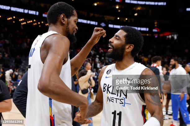 Kevin Durant of the Brooklyn Nets reacts withy Kyrie Irving after their 108-107 victory over the Atlanta Hawks at State Farm Arena on December 28,...