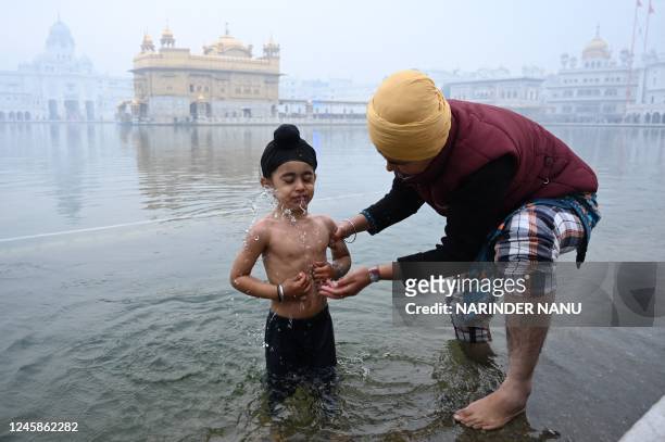 Young Sikh devotee takes a bath in the holy Sarovar on the occasion of the birth anniversary celebrations of the tenth Guru of the Sikhs Guru Gobind...