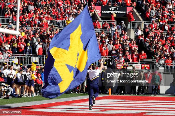 Michigan Wolverines cheerleader runs the Michigan banner in the end zone during the second quarter of the college football game between the Michigan...