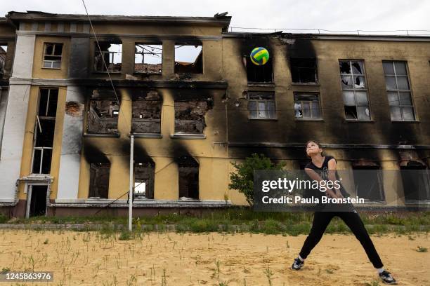 Girl plays volleyball with her father on June 24, 2022 in Kharkiv, Ukraine against the ruins of a school that was destroyed.One of the most common...