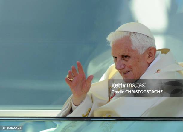 Pope Benedict XVI waves as he leaves in his popemobile after celebrating a mass in front of the Cathedral in Erfurt, eastern Germany, on September 24...