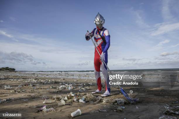 Japanese tourist cosplayed as Ultraman character cleans up trashes that washed ashore in Kuta Beach, Bali, Indonesia on December 29, 2022. During...