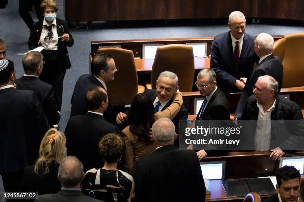 Israeli Prime Minister Benjamin Netanyahu and government members react after sworn in at the Israeli parliament during a new government sworn in...