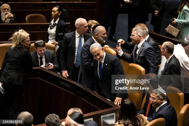 Israeli Prime Minister Benjamin Netanyahu and government members react after sworn in at the Israeli parliament during a new government sworn in...