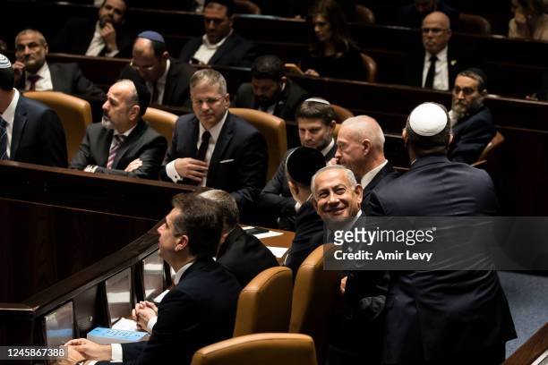 Israeli Prime Minister Benjamin Netanyahu and government members react after sworn in at the Israeli parliament during a new government sworn in...
