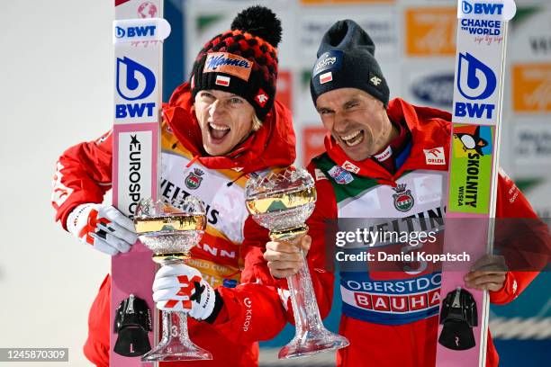 Dawid Kubacki and Piotr Zyla both of Poland celebrate on the podium after the second round of the Individual HS137 at the Four Hills Tournament Men...