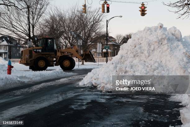 An excavator piles up snow on the east side of Buffalo, New York, on December 29, 2022. - The death toll from a fierce winter storm that gripped much...