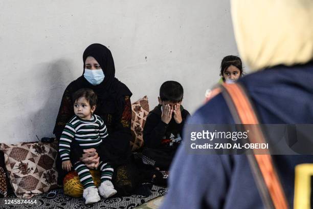 Alia Abdel-Razak, a woman deprived of crucial civil status documents, speaks to a lawyer in her home in Iraq's northern city of Mosul on December 11,...