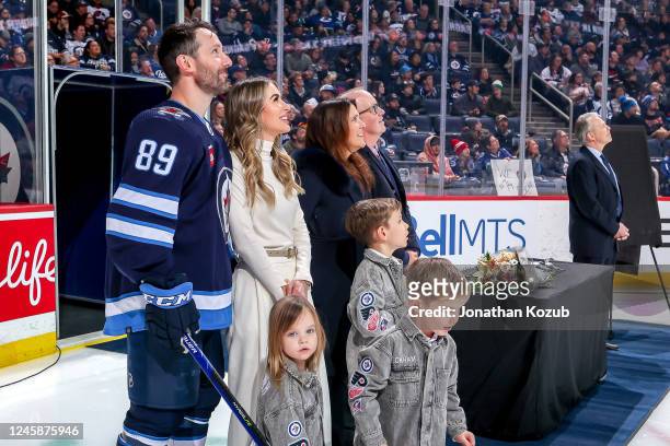 Sam Gagner of the Winnipeg Jets and his family watch a video tribute in celebration of his milestone 1000 career NHL games before action against the...