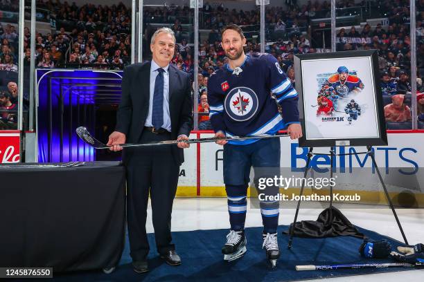 General Manager Kevin Cheveldayoff of the Winnipeg Jets presents a silver stick to Sam Gagner to commemorate his 1000 NHL games milestone prior to...