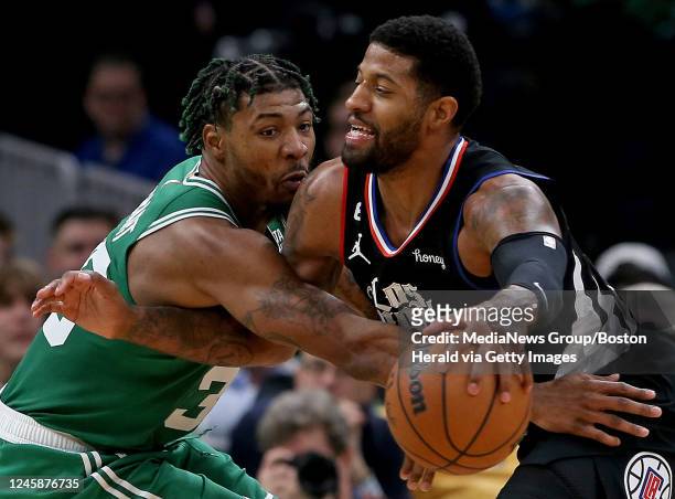 December 29: Marcus Smart of the Boston Celtics tries to stop Paul George of the LA Clippers during the first half of the NBA game at the TD Garden...