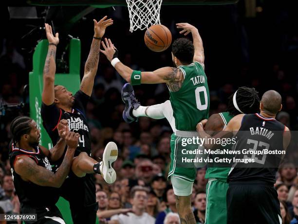 December 29: Jayson Tatum of the Boston Celtics loses the ball as Norman Powell of the LA Clippers defends the basket while Nicolas Batum holds back...