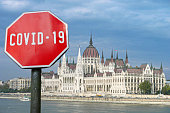 Covid-19 sign with parliament building in Budapest, Hungary