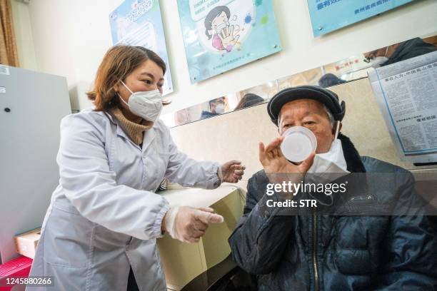 This photo taken on December 29, 2022 shows a health worker administering a dose of CanSino Biologics inhalable Covid-19 coronavirus vaccine in...