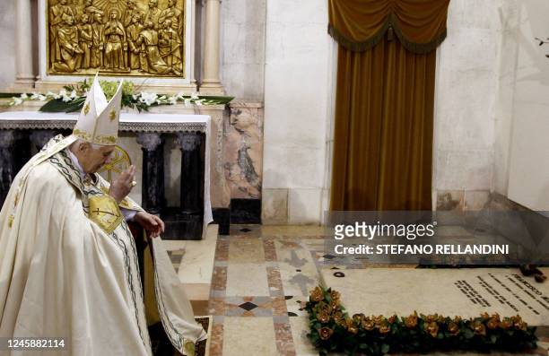 Pope Benedict XVI prays by the three little shepherds' tomb during the traditional annual celebrations at Fatima's Sanctuary in Portugal on May 13,...