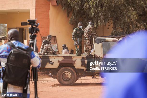 Journalists and military personnel wait outside the Court of Appeal in Bamako where the trial of the 46 Ivorian soldiers arrested in Mali takes place...