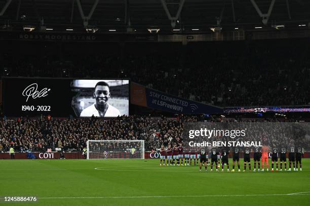 Players and officials observe a minute's silence to honour Brazilian football legend Pele, who died on December 29, ahead of the English Premier...