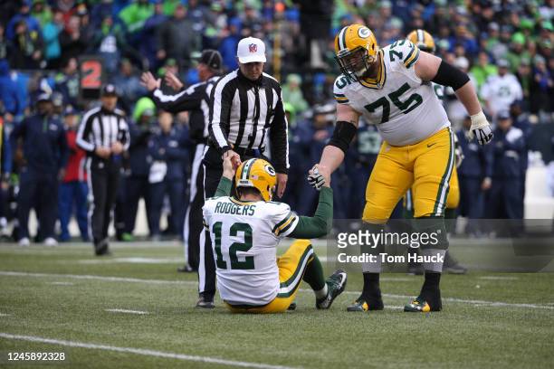 Green Bay Packers quarterback Aaron Rodgers gets help up from the official at the 2015 NFC Championship game between the Seattle Seahawks against the...