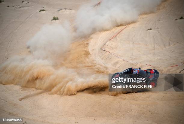 Audi's hybrid Spanish drivers Carlos Sainz and co-driver Lucas Cruz compete during the prologue of the Dakar 2023 by the Red Sea in Yanbu, Saudi...