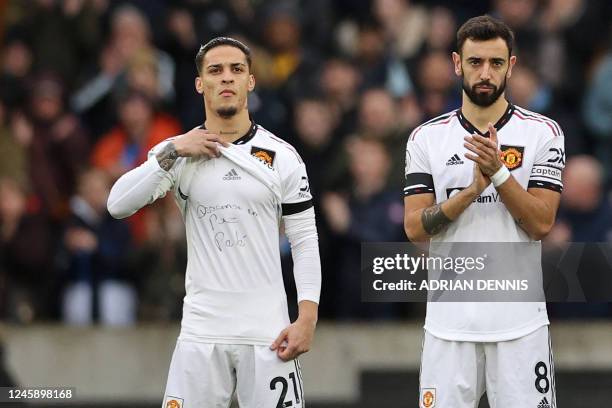 Manchester United's Brazilian midfielder Antony displays a message on his shirt as players and officials observe a minute's applause to honour...