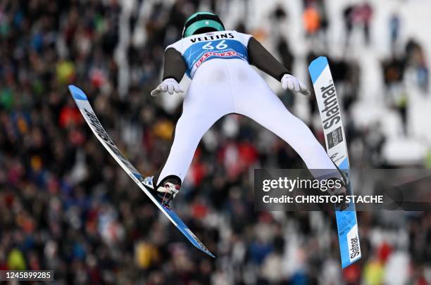 Slovenia's Anze Lanisek soars through the air above spectators during the qualification round of the Four Hills FIS Ski Jumping tournament in...