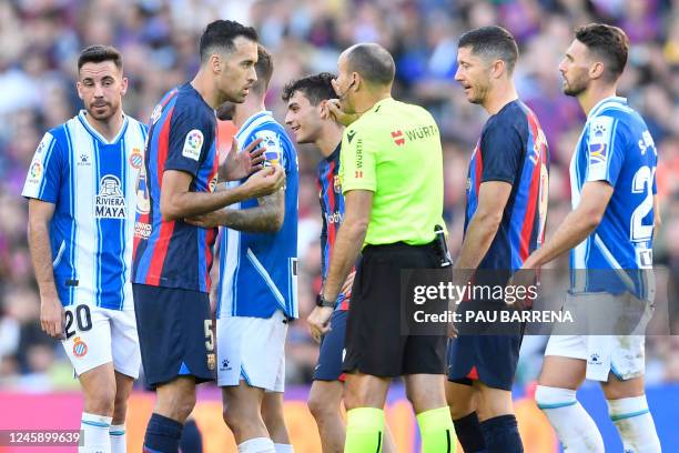 Barcelona's Spanish midfielder Sergio Busquets talks with Spanish referee Mateu Lahoz during the Spanish League football match between FC Barcelona...