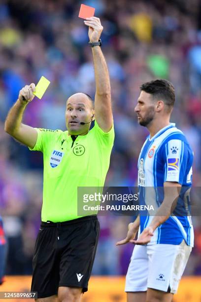Spanish referee Mateu Lahoz presents a red card to Espanyol's Brazilian midfielder Vinicius Souza during the Spanish League football match between FC...