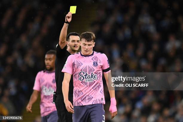 Everton's Scottish defender Nathan Patterson is shown a yellow card by English referee Andrew Madley during the English Premier League football match...