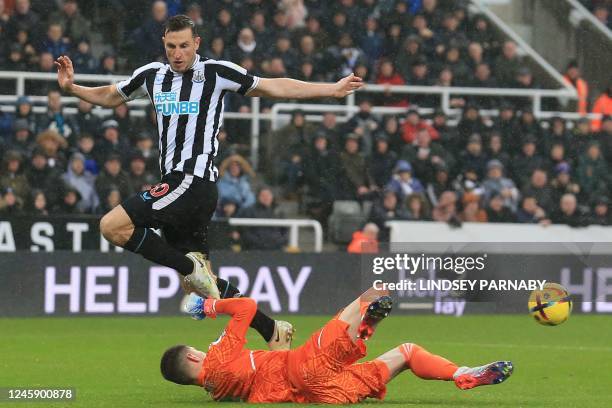 Leeds United's French goalkeeper Illan Meslier saves at the feet of Newcastle United's New Zealand striker Chris Wood during the English Premier...