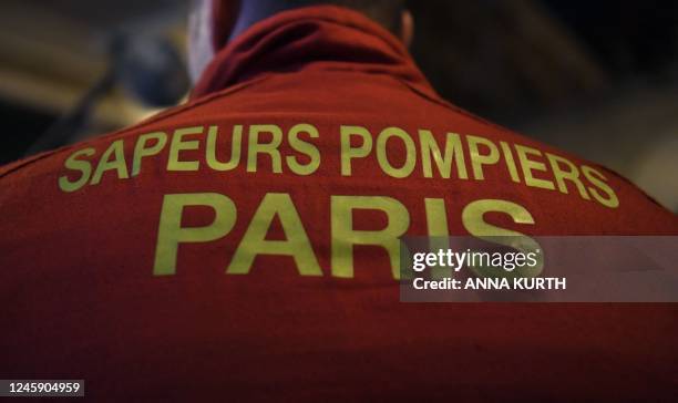 This photograph taken in Paris on December 31, 2022 shows a firefighter wearing a jacket marked "Paris' firefighters".