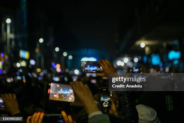 People capture the moment on their phone as they gather at Thamel, a tourist hub to celebrate the New Year Eve in Kathmandu, Nepal on December 31,...