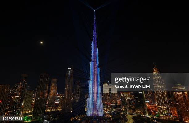 New Year's Eve light show illuminates the landmark Burj Khalifa tower at midnight in the Gulf emirate of Dubai on December 31, 2022.