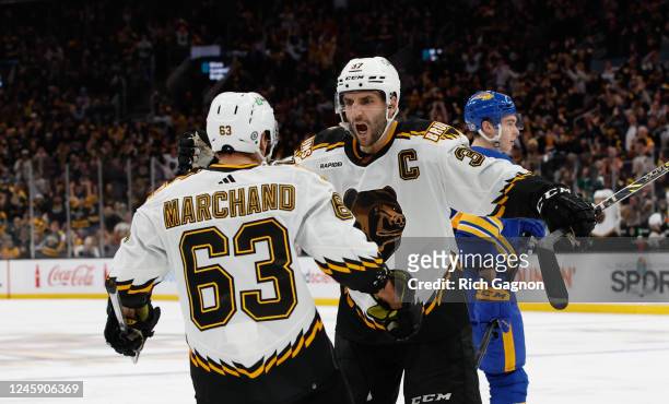 Patrice Bergeron of the Boston Bruins celebrates his goal against the Buffalo Sabres during the third period with teammate Brad Marchand at the TD...