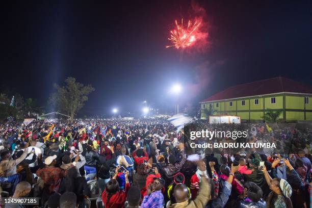 Fireworks light up the sky as people react while they celebrate after counting down to the new year at Miracle Center Cathedral in Kampala, Uganda,...