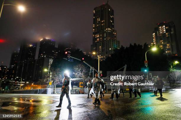 Los Angeles, CA, Saturday, December 31, 2022 - Clad in plastic ponchos, security workers head to their post near Grand Park before the gates open to...